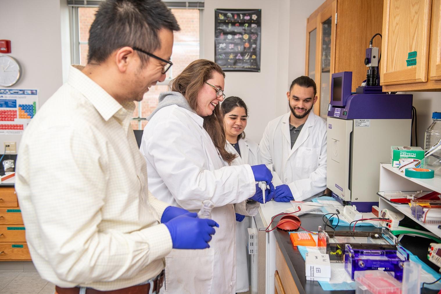 Dr. Hu in lab with students.